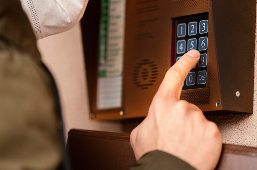 A person entering a code on a wall-mounted numeric keypad