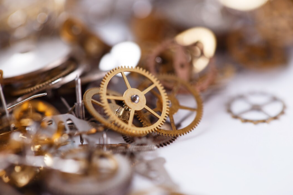 clockwork gears and components spread out on a white surface