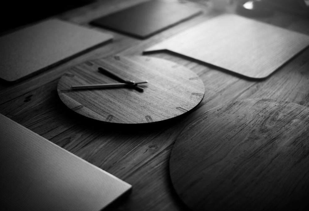 a wooden clock on a table, with ambient lighting emphasizing its form